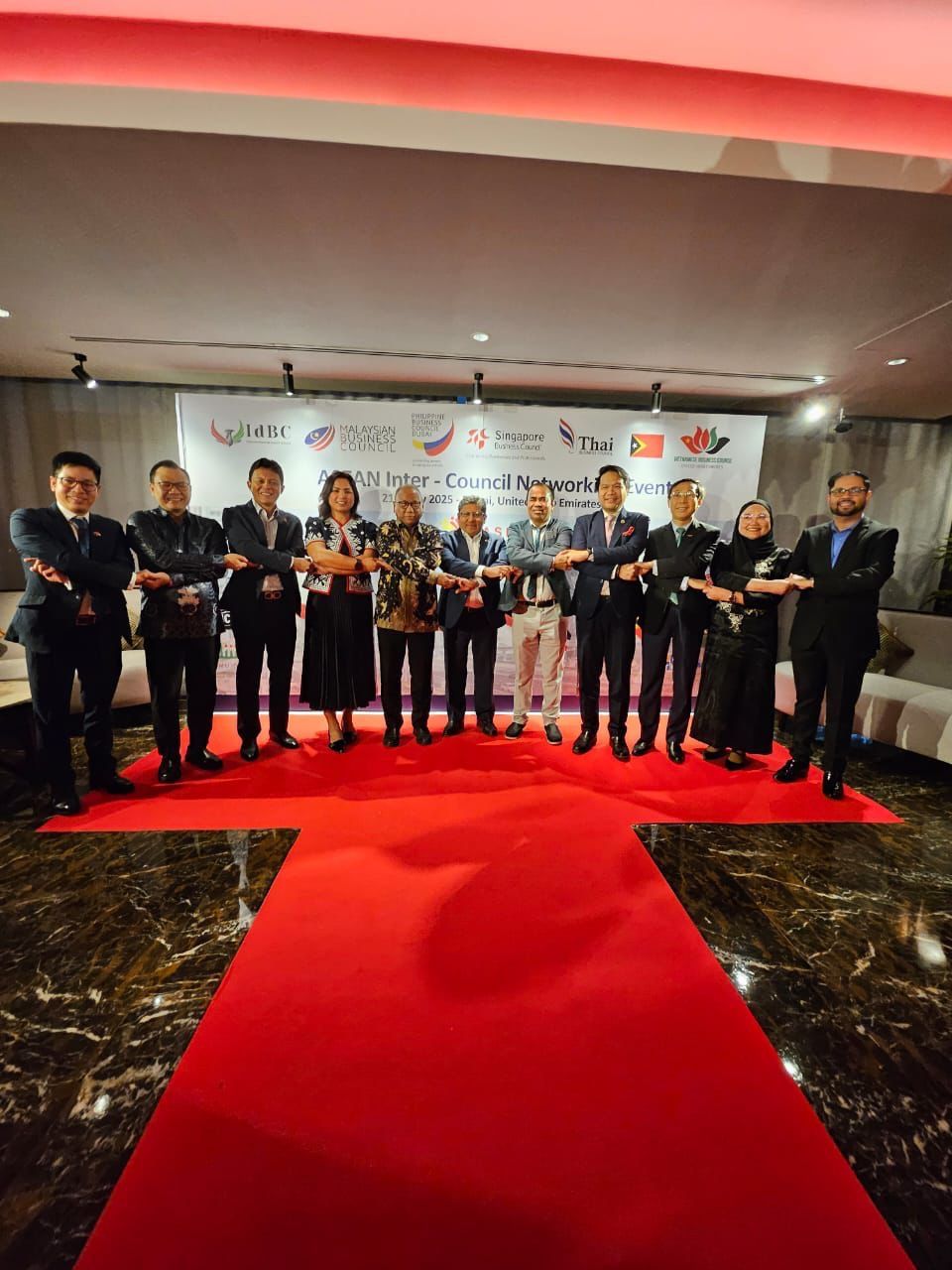 Representatives from SBC UAE and fellow ASEAN Business Councils Alliance members linking arms at the ASEAN Inter-Council Networking Event in Dubai